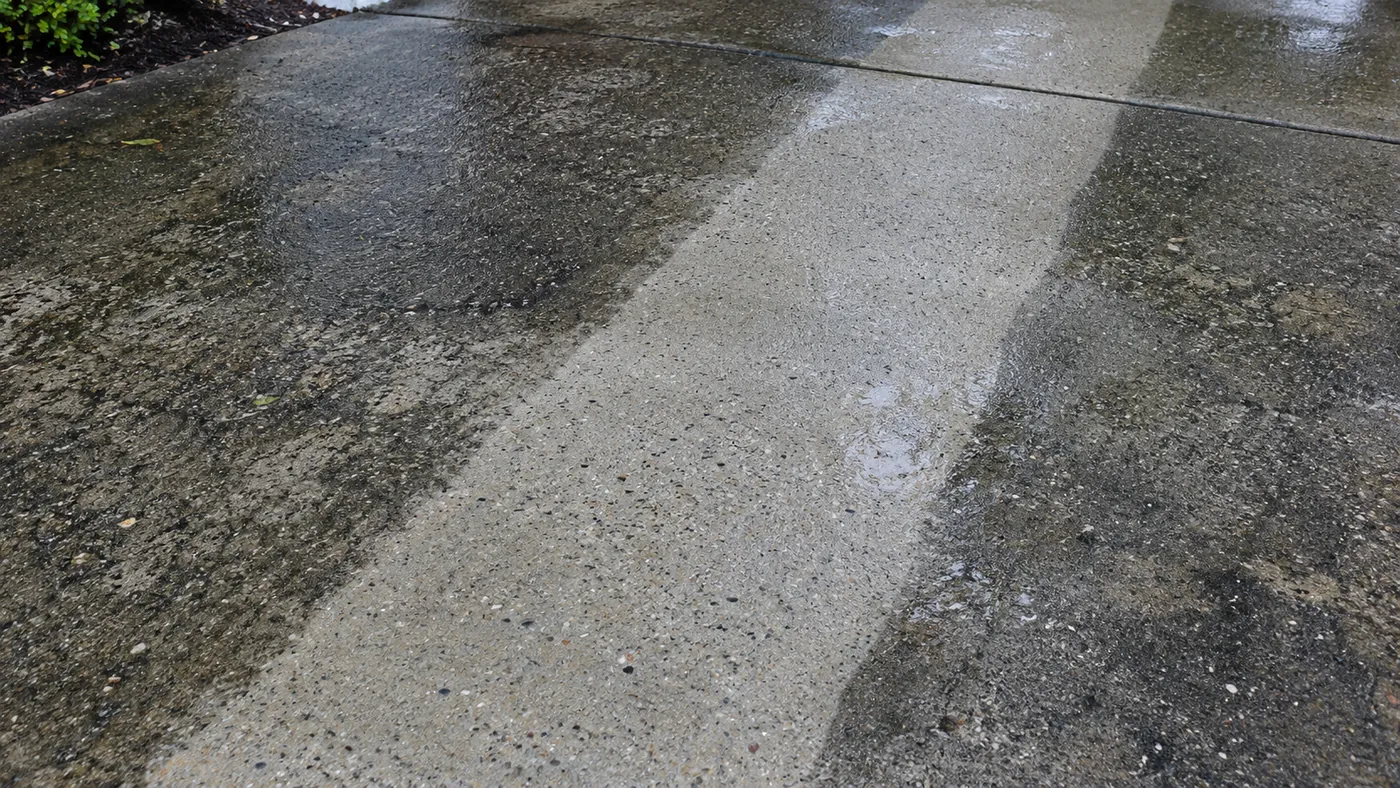 Driveway half cleaned with a surface cleaner